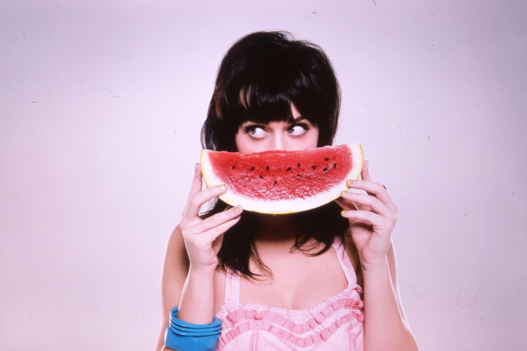 Katy Perry smelling the sweet scent of a watermelon.