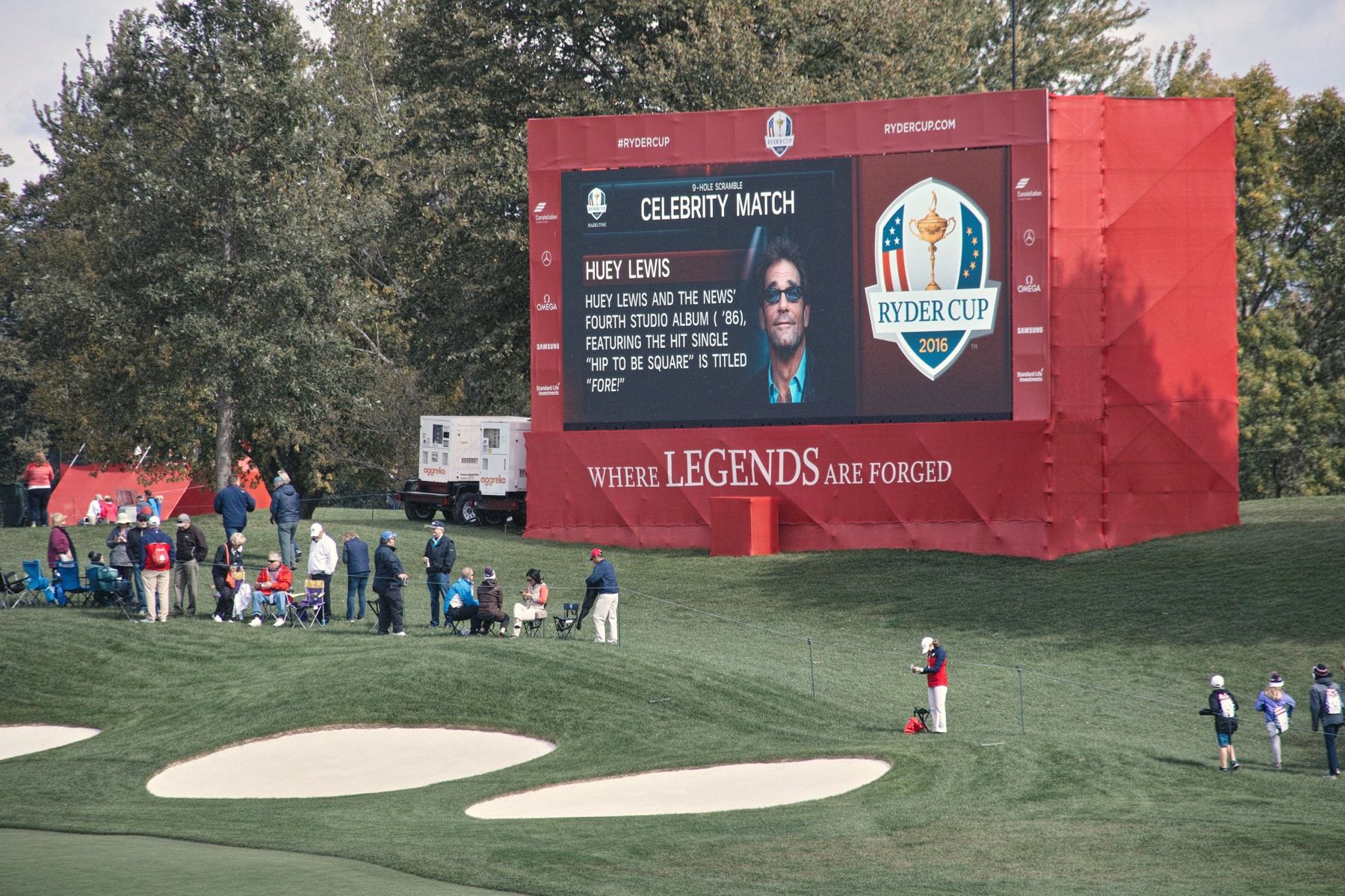 Fairway stand with electronic billboard containing picture of Huey Lewis